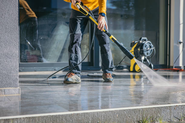 Man cleaning the terrace with high pressure cleaner on beautiful sunny day. Property Maintenance