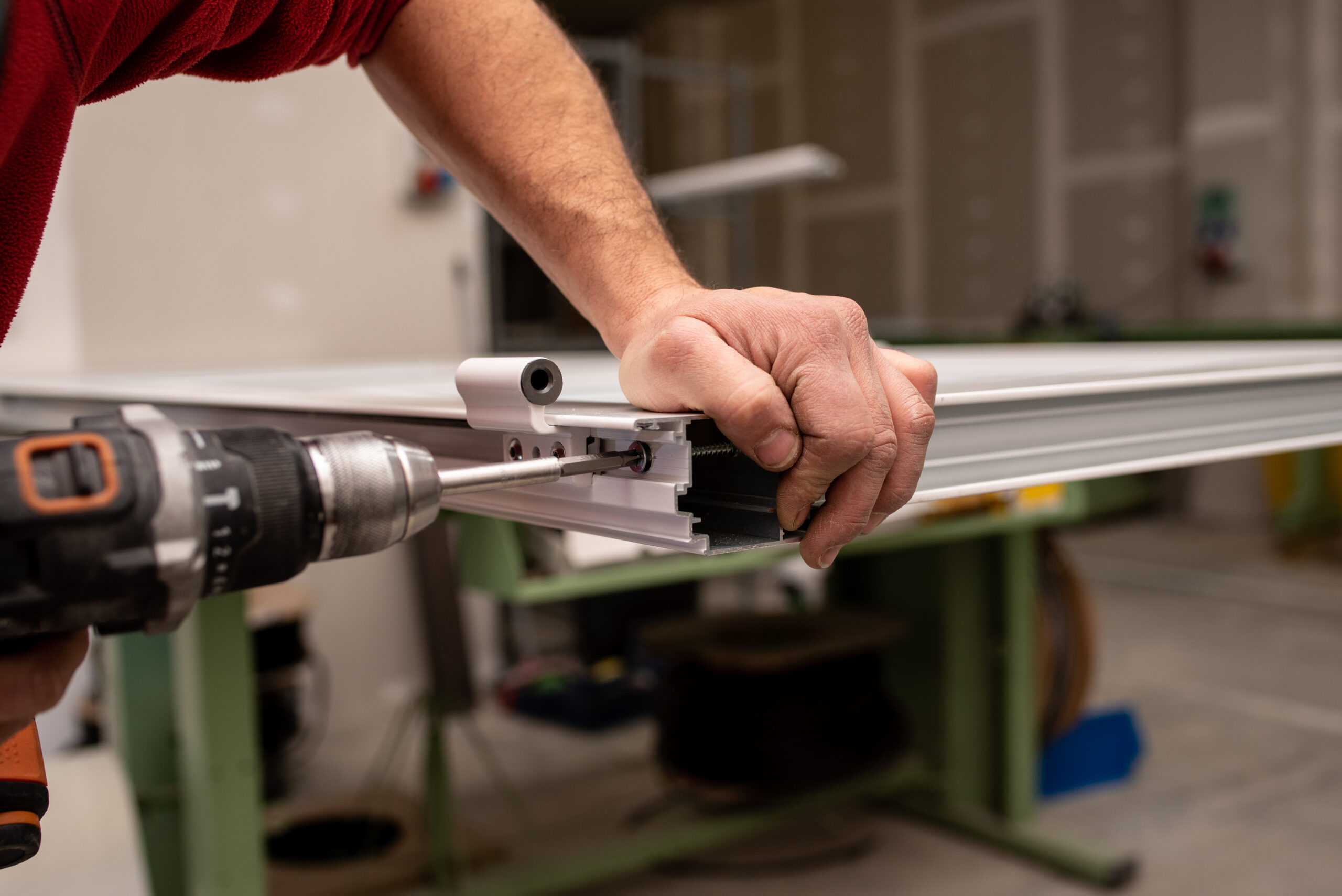 Male with a red shirt making a window with industrial tools Property Maintenance