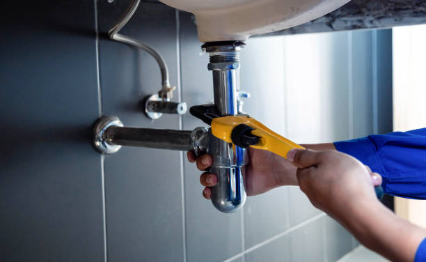 Plumber fixing white sink pipe with adjustable wrench. Property Maintenance